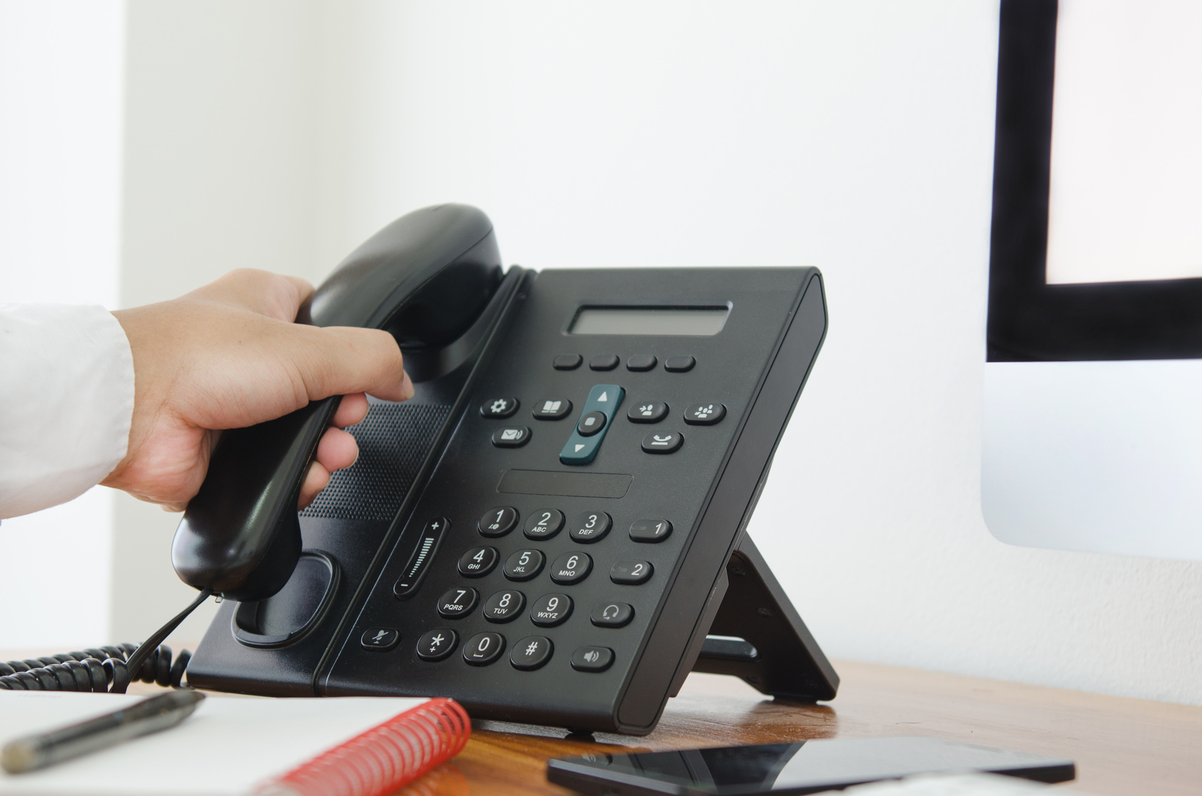 hand hold a telephone in the office for contact customer support